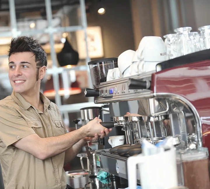 Barista preparando café en la máquina (foto ilustrativa)